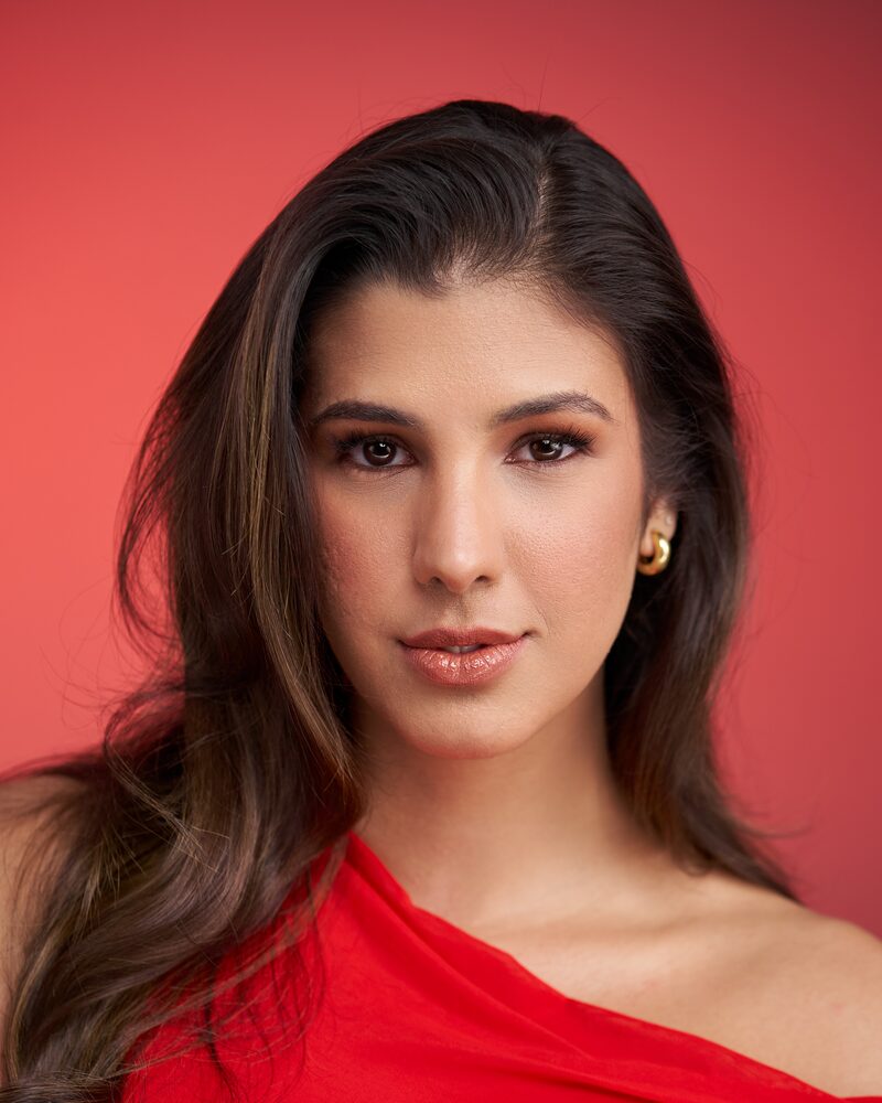 Jeannet Garcia formal portrait — red one-shoulder dress, red backdrop